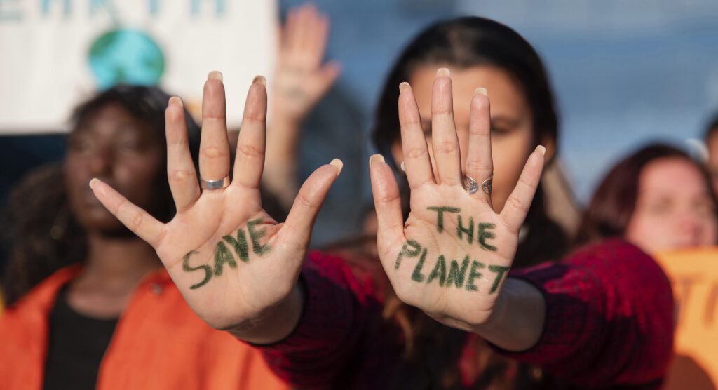 Manifestantante qui tends ses mains à l'intérieur desqu'elles il y a écris: "Save The Planet"